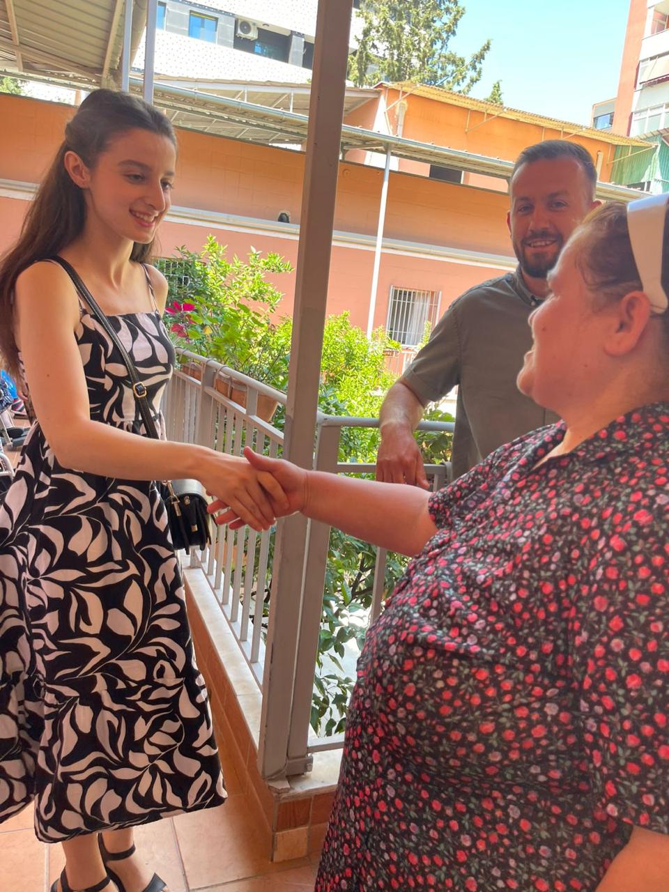 A youth participant greets a resident during the intergenerational initiative at the Missionaries of Charity Home for the Elderly.